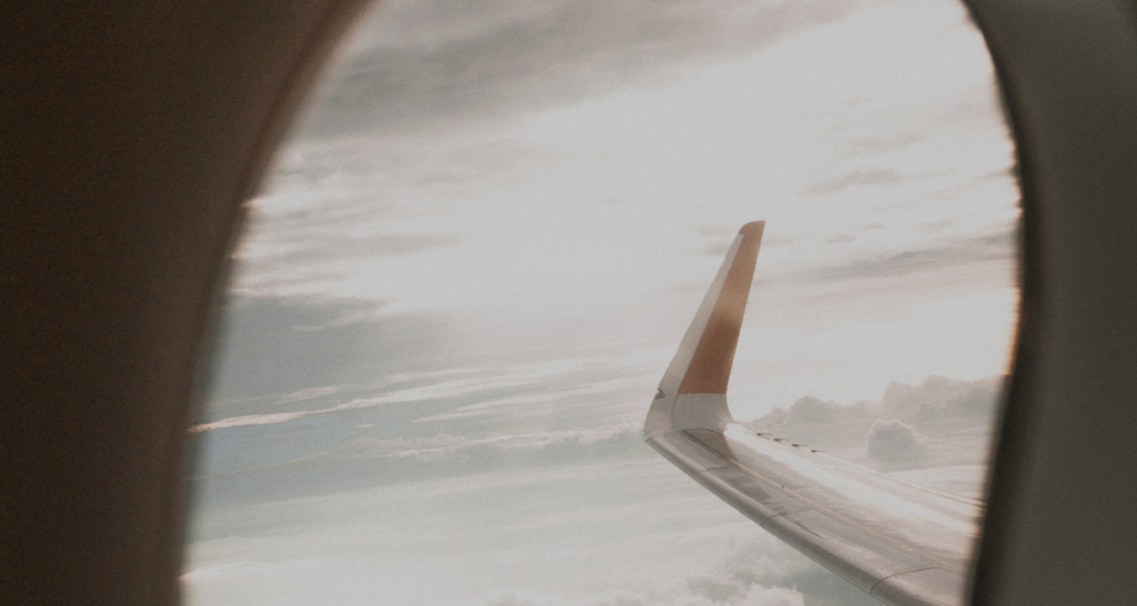 One million miles above the clouds with an airplane wing at cruising altitude, capturing the quiet perspective of sky‑life travel.