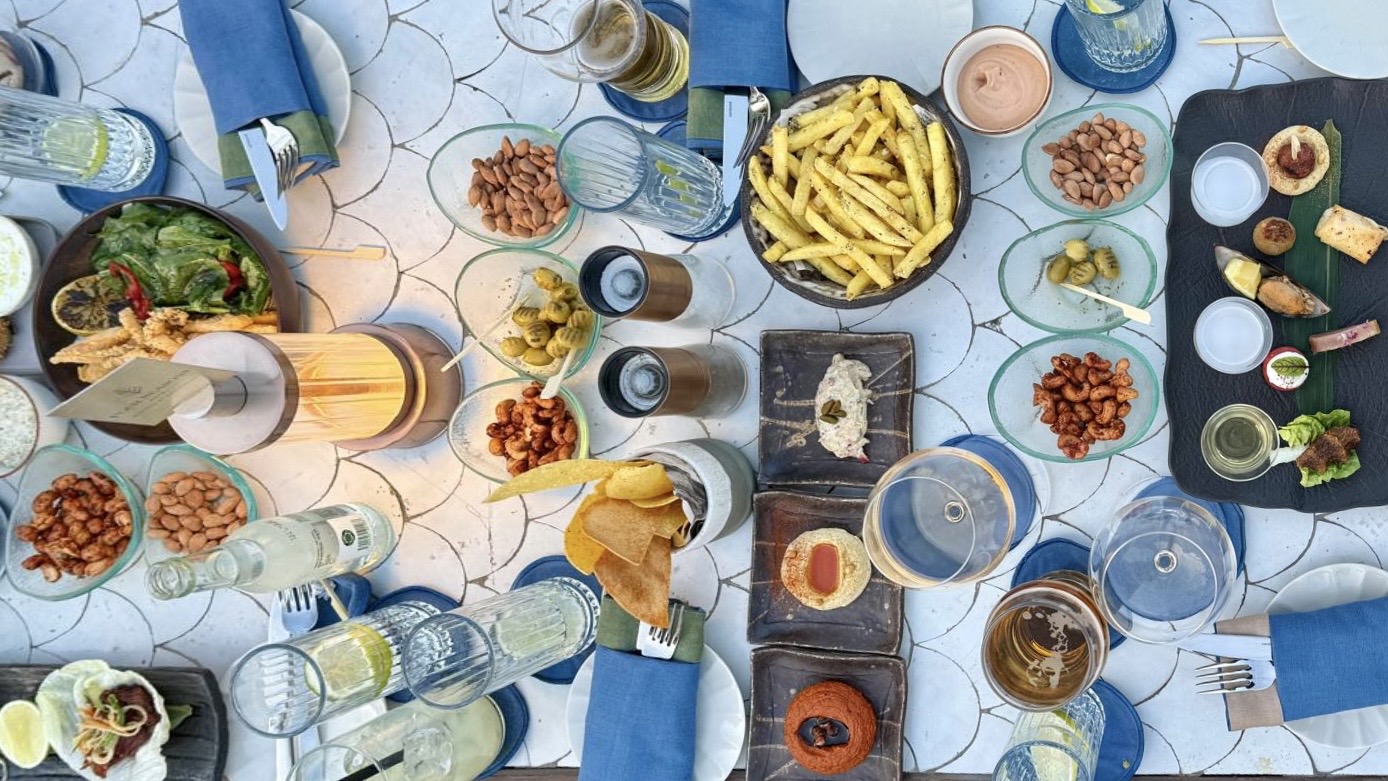 Overhead view of shared mezze dishes, drinks, bread, olives, and appetizers gathered around a rooftop table at Four Seasons Istanbul during the Starseed Türkiye Adventure with Althea Provost.